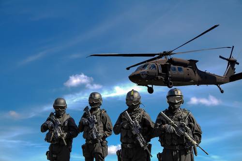 Military man with helicopter hovering in the air Stock Photo