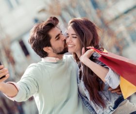 Portrait of a couple with shopping bags in city Stock Photo 01