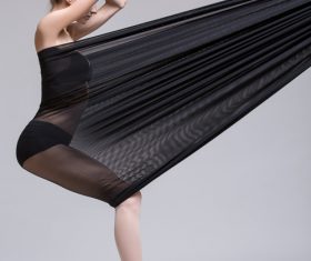 Slim dancer plays with black mesh fabric in the studio Stock Photo 05