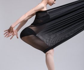 Slim dancer plays with black mesh fabric in the studio Stock Photo 07