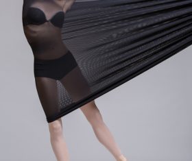 Slim dancer plays with black mesh fabric in the studio Stock Photo 08