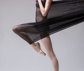 Slim dancer plays with black mesh fabric in the studio Stock Photo 09