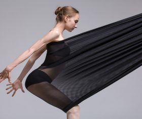 Slim dancer plays with black mesh fabric in the studio Stock Photo 12