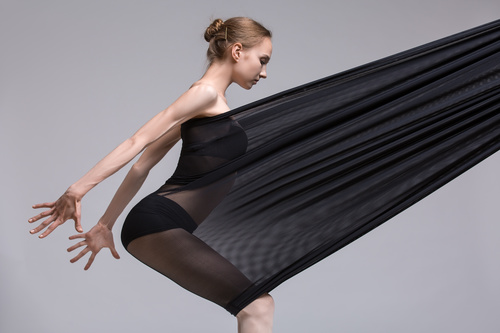 Slim dancer plays with black mesh fabric in the studio Stock Photo 12