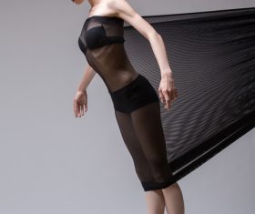 Slim dancer plays with black mesh fabric in the studio Stock Photo 14