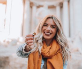Smiling woman holding coins Stock Photo