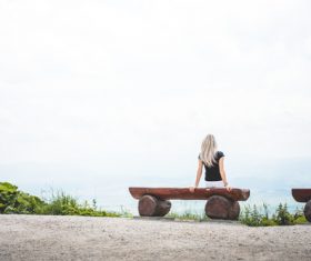 Woman Sitting on a Bench look at the scenery Stock Photo