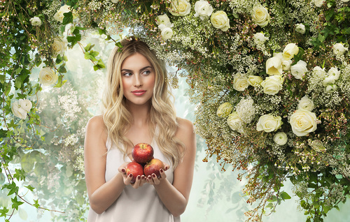 Woman holding apple with flower background Stock Photo