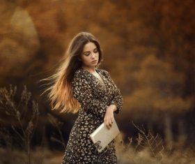 Woman holding book posing outdoors Stock Photo