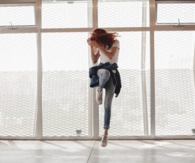 Woman jumping indoors Stock Photo