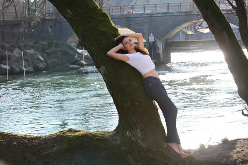 Woman leaning on a tree by the river Stock Photo