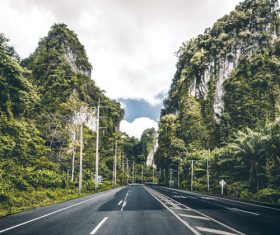 Asphalt road with mountains on both sides Stock Photo