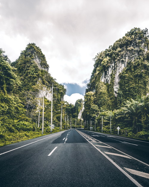 Asphalt road with mountains on both sides Stock Photo