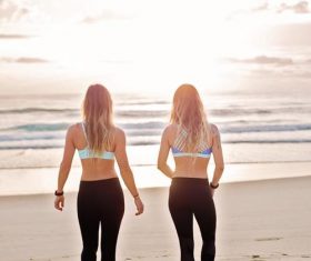Back view of two women walking on the beach Stock Photo