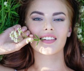 Closeup of beautiful woman lying on the grass Stock Photo
