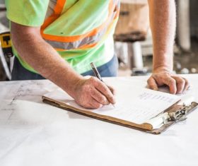 Construction worker writing on notepad Stock Photo