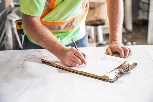 Construction worker writing on notepad Stock Photo