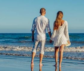 Couple holding hands by the sea Stock Photo