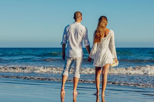 Couple holding hands by the sea Stock Photo