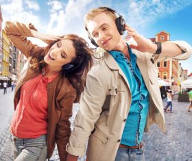 Couples wearing headphones to listen to music in the city square Stock Photo 02