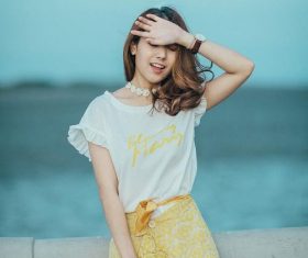 Curly girl covers the sun by hand Stock Photo