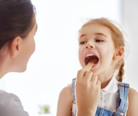 Doctor doing oral examination for little girl Stock Photo