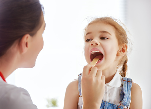 Doctor doing oral examination for little girl Stock Photo
