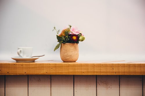 Flower arrangement and coffee cup on the windowsill Stock Photo