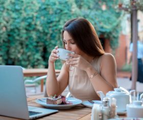 Girl drinking coffee in outdoor cafe Stock Photo