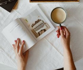 Girl drinking coffee while reading book Stock Photo 02