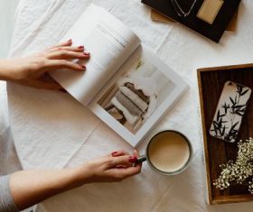 Girl drinking coffee while reading book Stock Photo 03