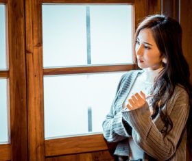 Girl standing in the window staring into the distance Stock Photo