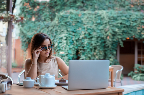 Girl wearing sunglasses in outdoor cafe Stock Photo