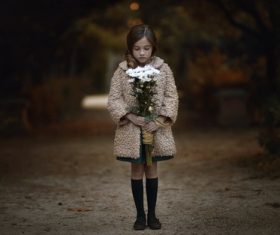 Little girl looking down at the bouquet in hand Stock Photo