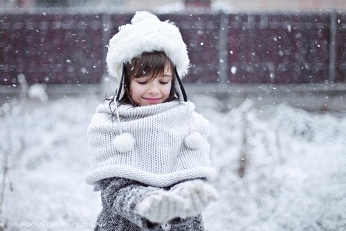 Little girl playing snow outdoors on snowy day Stock Photo