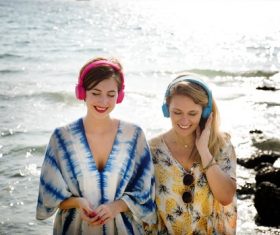 Mother and daughter with headphones at the seaside Stock Photo