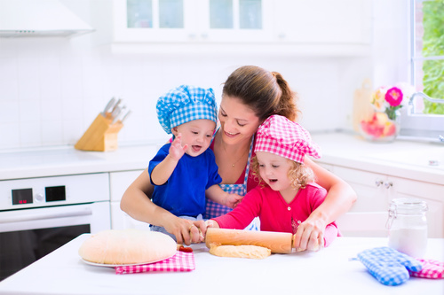 Mother and two children in the kitchen Stock Photo