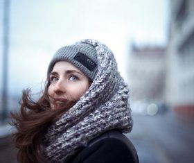 Outdoor blue eyes woman wearing knitted hat around scarf Stock Photo