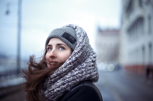 Outdoor blue eyes woman wearing knitted hat around scarf Stock Photo