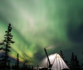 Outdoor night bright tents and Northern Lights Stock Photo