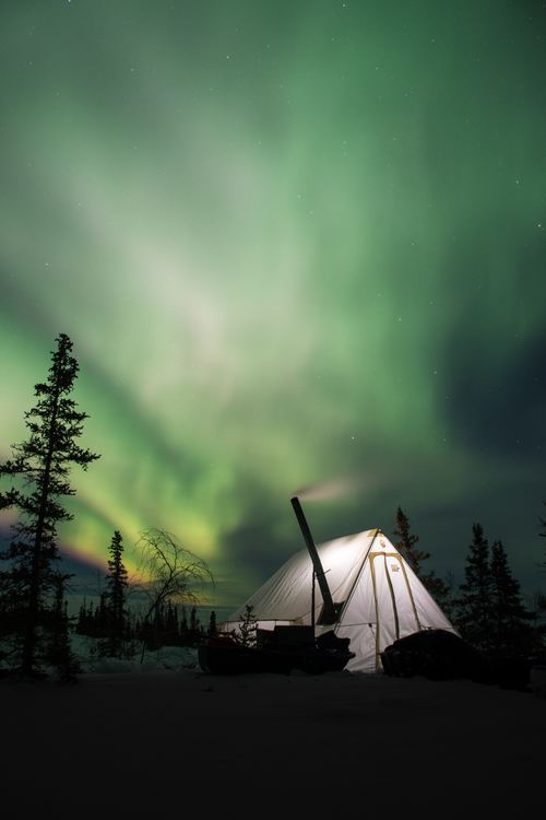 Outdoor night bright tents and Northern Lights Stock Photo