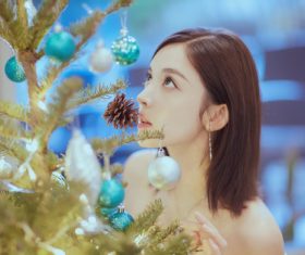 Pretty asian girl looking at christmas tree Stock Photo 01