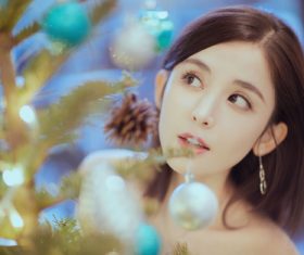 Pretty asian girl looking at christmas tree Stock Photo 02