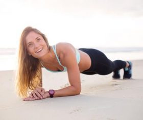 Stock Photo Woman doing push-ups on the beach
