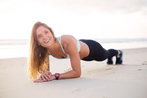Stock Photo Woman doing push-ups on the beach