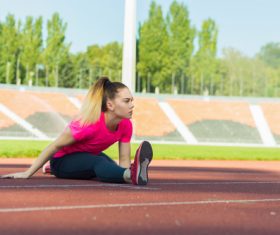 Stock Photo Woman doing stretching exercise on the stadium