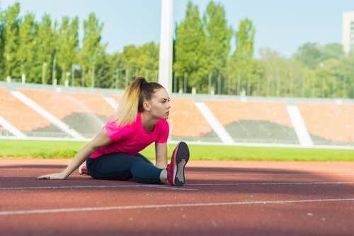 Stock Photo Woman doing stretching exercise on the stadium