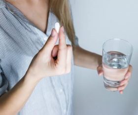 Stock Photo Woman holding water and pills Stock Photo