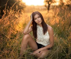Stock Photo Woman sitting on the barren grass