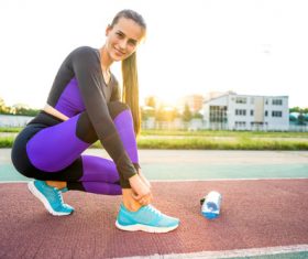 Stock Photo Woman tying shoelaces on the runway